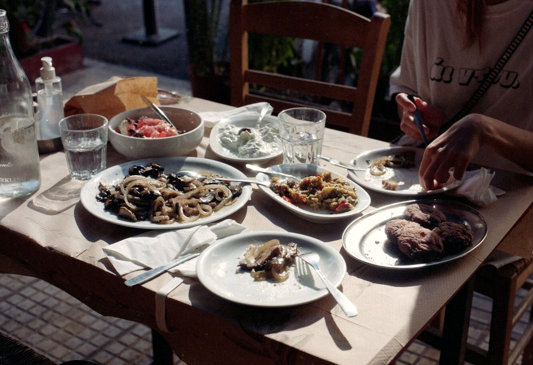 Tisch einer griechischen Taverne im Freien, Gerichte zum Teilen - Griechenland