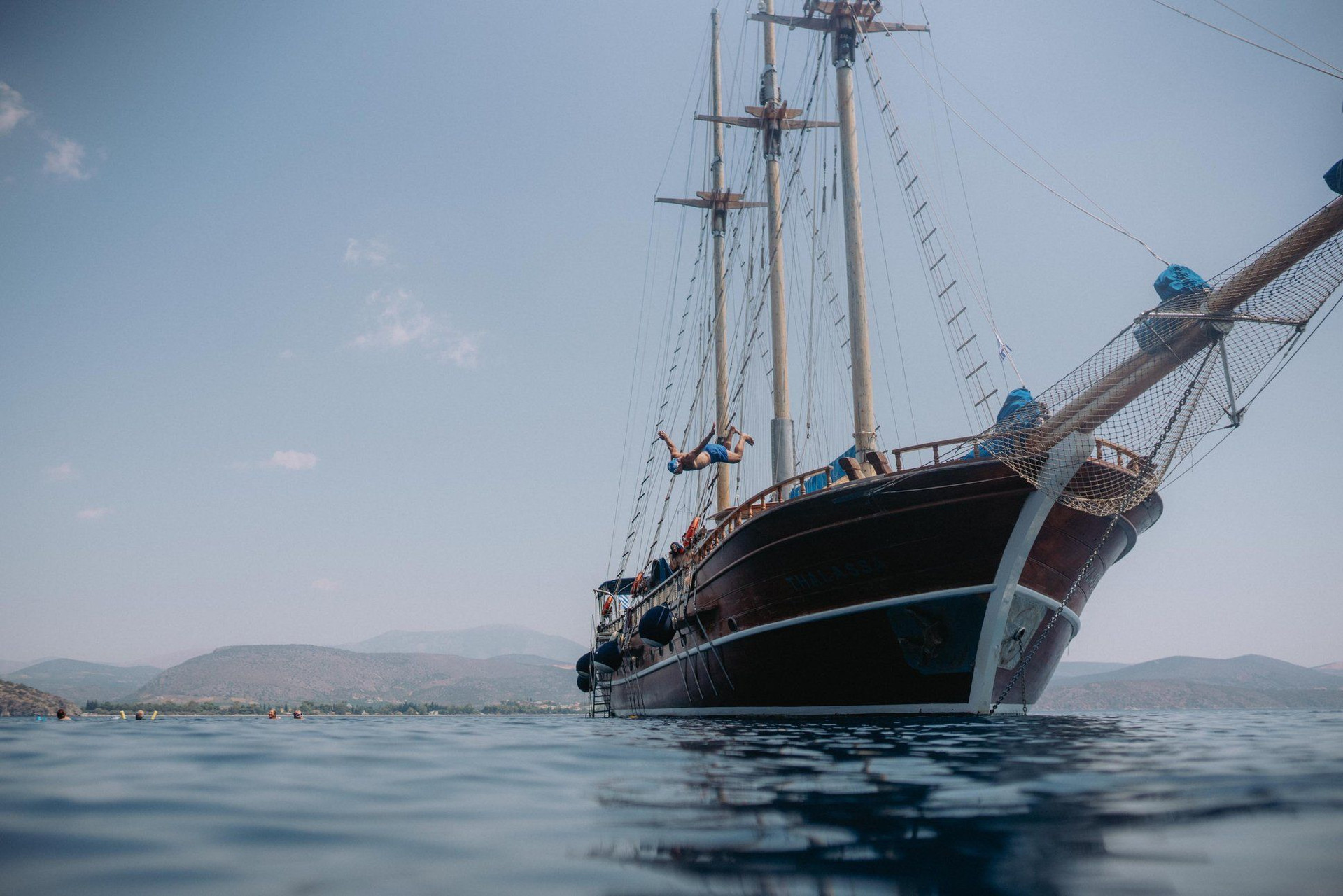 Goélette traditionnelle au mouillage et baigneurs - mer Égée - Grèce © Kleomenis Koufaliotis