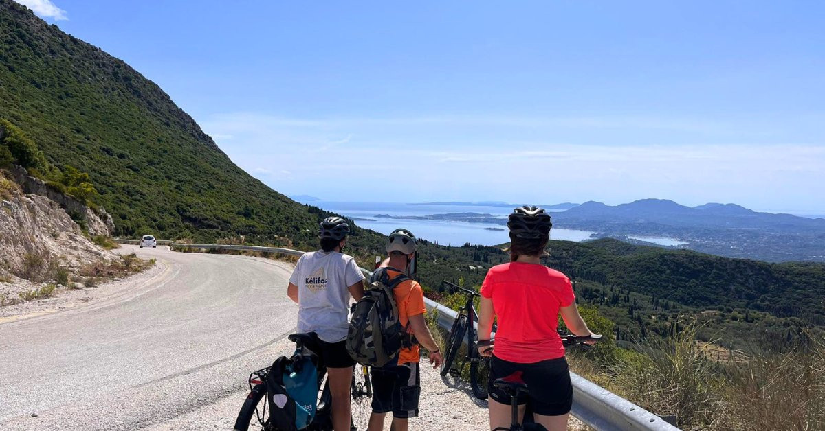 Radfahrer oberhalb einer türkisfarbenen Bucht - Korfu - Griechenland